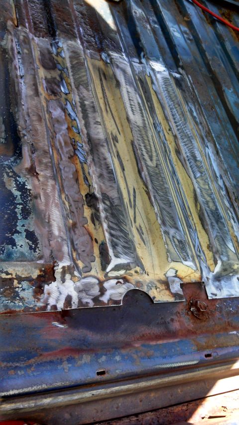 1979 Ford Bronco - Close-up of a heavily rusted and welded metal surface, likely a vehicle floor panel.