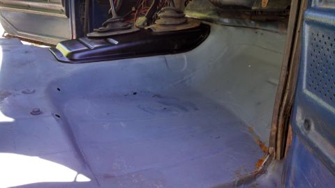 1979 Ford Bronco - The bare metal floor of the vehicle's interior shows signs of wear and some rust near the door jamb.