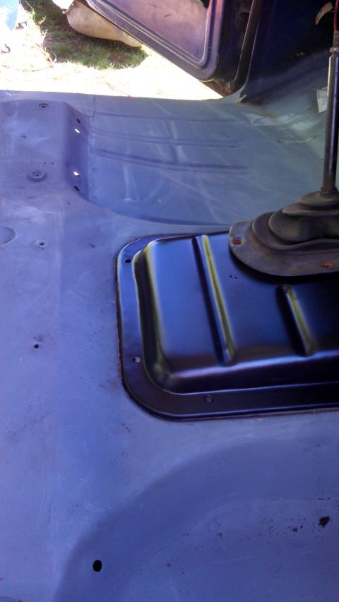 1979 Ford Bronco - The interior floor of a vehicle shows a transmission tunnel cover and shifter boot.