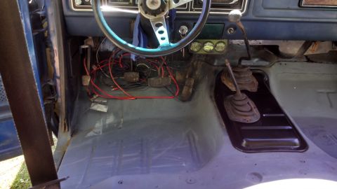 1979 Ford Bronco - The interior of a 1979 Ford Bronco reveals its floor, pedals, steering wheel, and gear shifter.