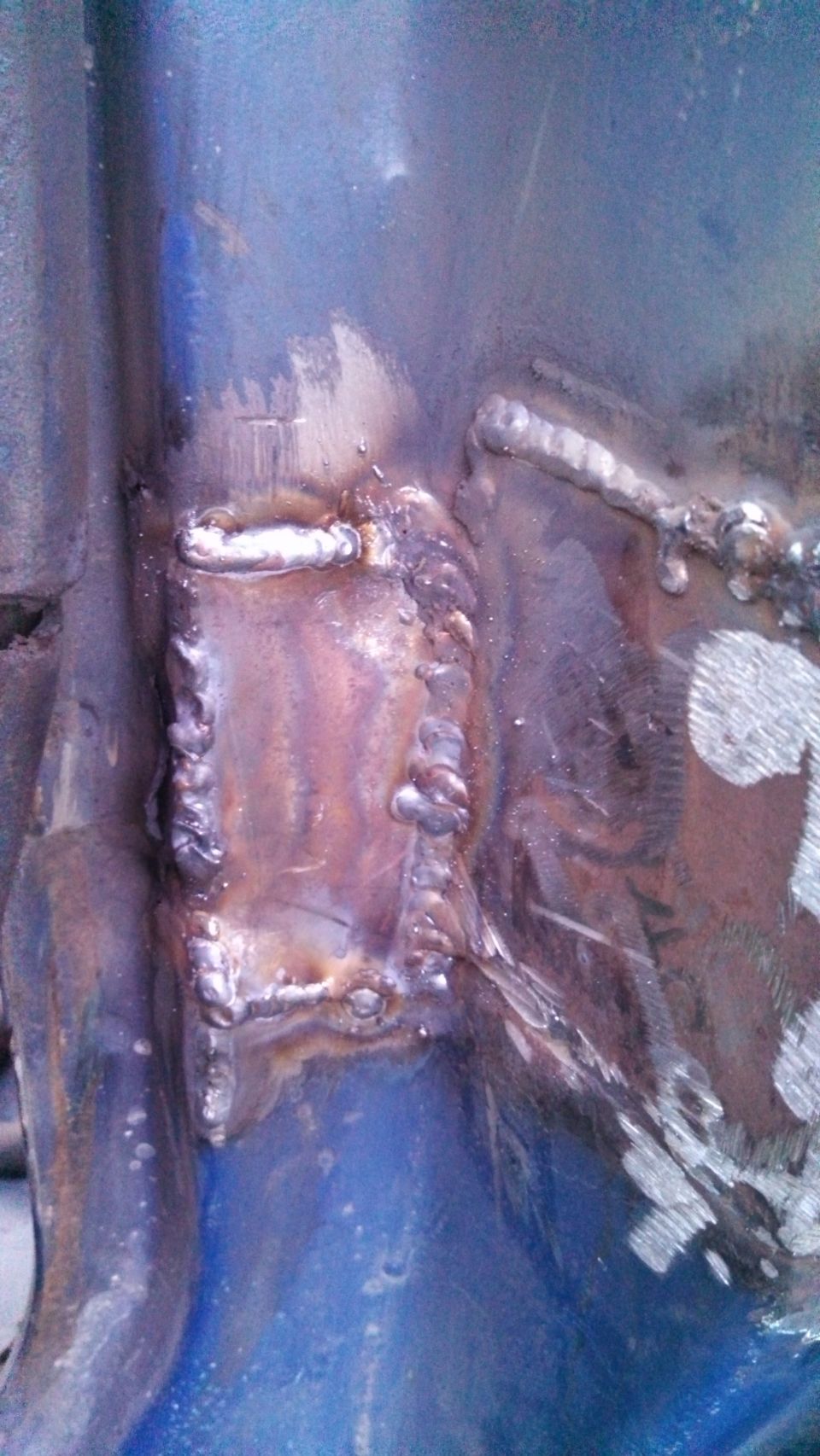 Close-up of welded metal frame with blue paint