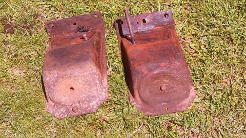 1979 Ford Bronco - Two heavily rusted metal brackets with bolts are shown on grass.