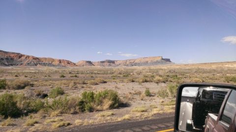 1994 Ford Bronco - View of a desert landscape with mesas and mountains, captured from a vehicle.