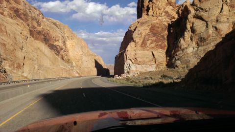 1994 Ford Bronco - Driving through a scenic canyon with towering rock formations under a partly cloudy sky.