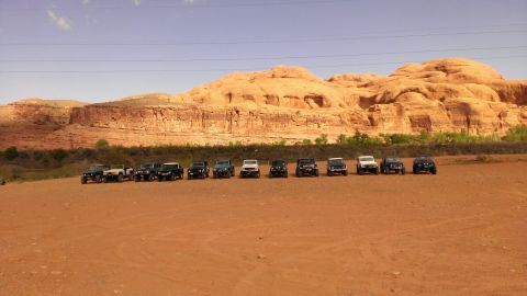 1994 Ford Bronco - A group of SUVs are lined up in a desert environment with large rock formations behind them.