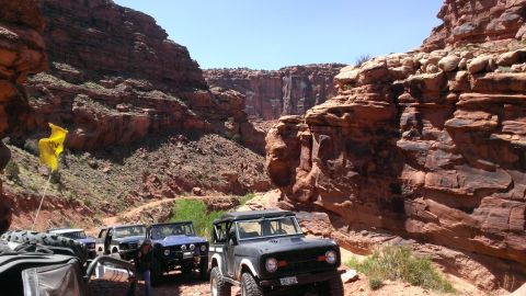 1994 Ford Bronco - Off-road vehicles navigate a canyon trail, with multiple SUVs visible.