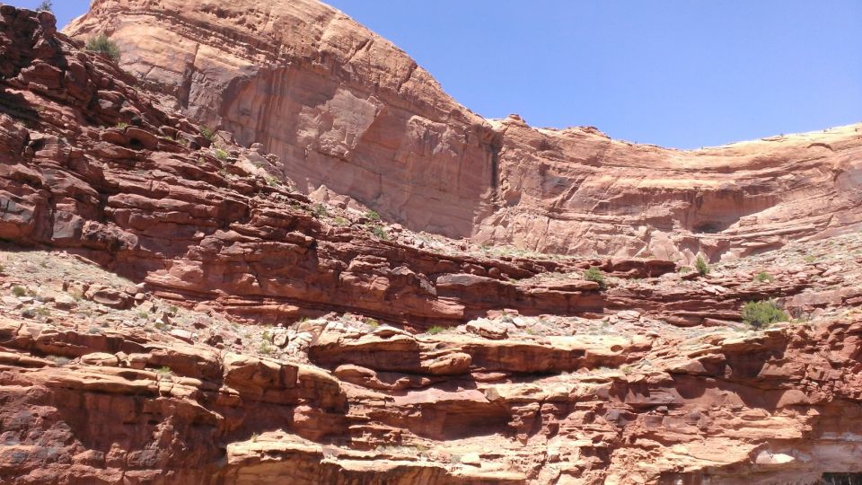 Layered red rock cliffs under a clear blue sky. A watermark reads 'SUPER MOTORS www.supermotors.net'
