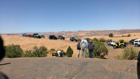 1994 Ford Bronco - A group of off-road vehicles are gathered in a desert landscape under a clear blue sky.