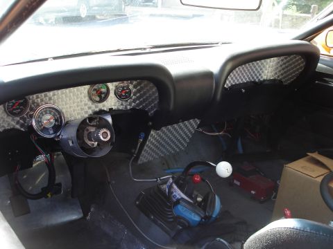 1970 Ford Mustang - The interior of a 1970 Ford Mustang shows custom gauges and a racing shifter, suggesting a modified build.