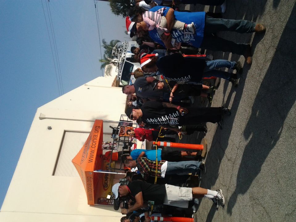 White truck with people in front of a building and an orange tent