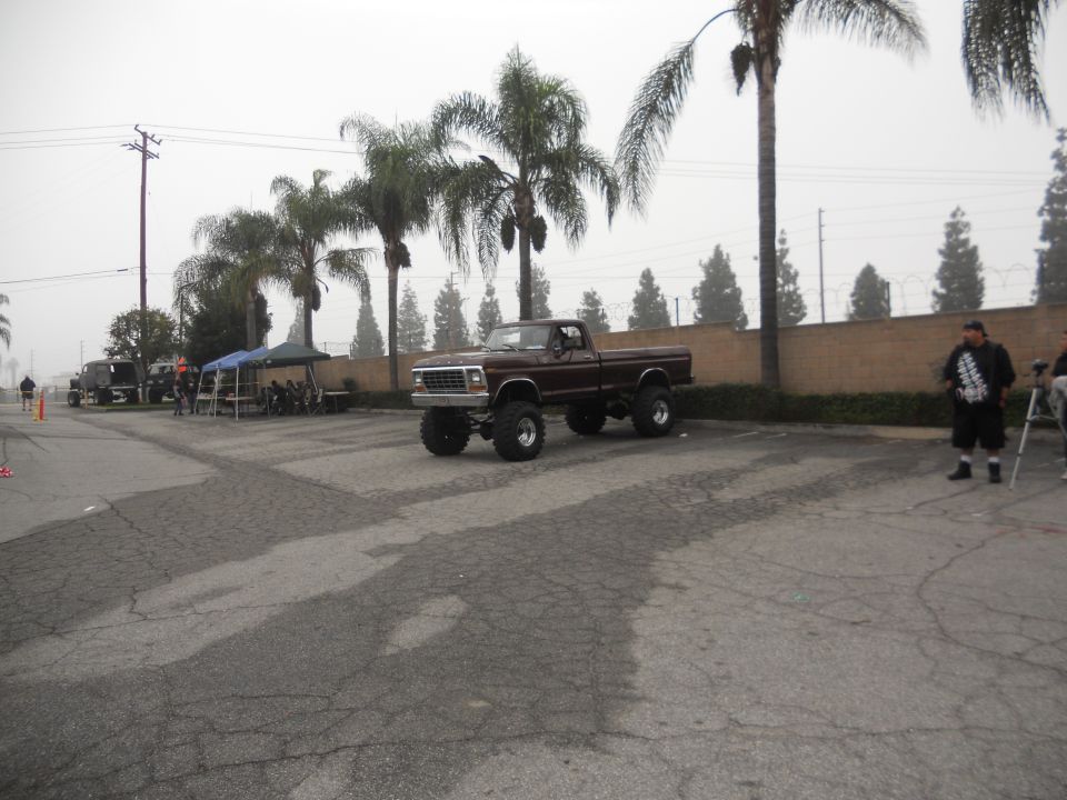 Brown lifted pickup truck with large tires, seen from a 3/4 front angle