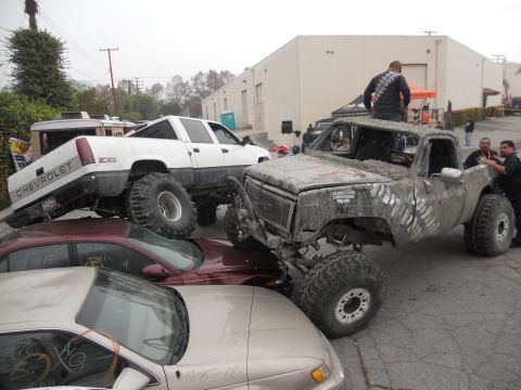 1986 Ford Bronco - A heavily modified pickup truck is parked on top of several other vehicles.