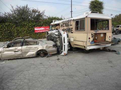 1986 Ford Bronco - A scene of destruction shows a wrecked sedan and an overturned vehicle beside a bus.