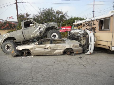 1986 Ford Bronco - Multiple vehicles involved in a severe collision, with one truck crushing a sedan.