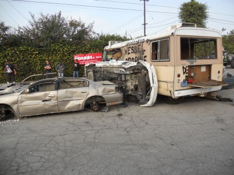 1986 Ford Bronco - Two heavily damaged vehicles are shown after an apparent collision, with onlookers present.