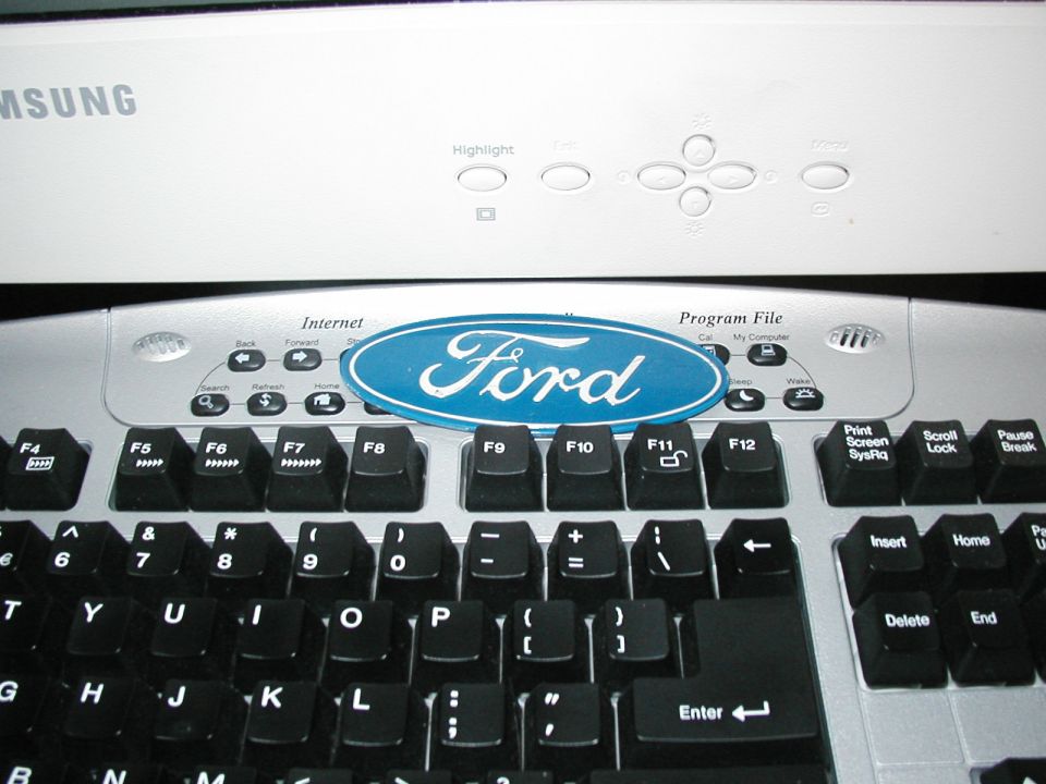 Ford logo on a computer keyboard with Samsung monitor above