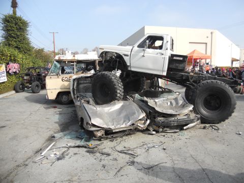1986 Ford Bronco - Monster truck crushing several cars in a parking lot scene.