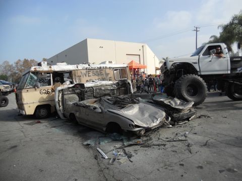 1986 Ford Bronco - A scene of destruction with multiple vehicles, including a van and a crushed car, under a monster truck.