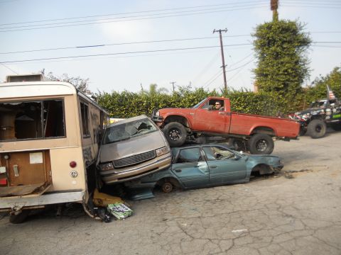 1986 Ford Bronco - A chaotic scene shows multiple vehicles piled up, including a bus, minivan, sedan, and a lifted pickup truck.