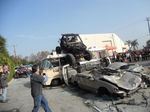 1986 Ford Bronco - A chaotic scene with multiple wrecked vehicles and an off-road buggy perched on top.