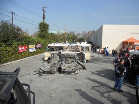 1986 Ford Bronco - A scene of destruction with a car overturned and an RV damaged, surrounded by onlookers.