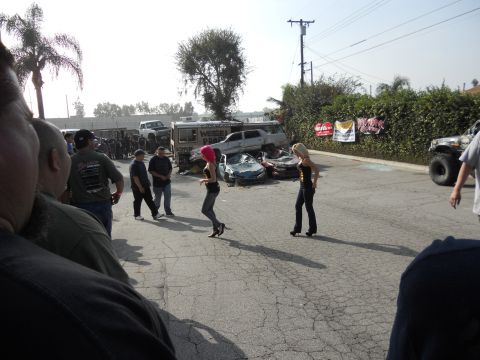 1986 Ford Bronco - A chaotic scene unfolds with damaged vehicles, two women, and a crowd of onlookers gathered.
