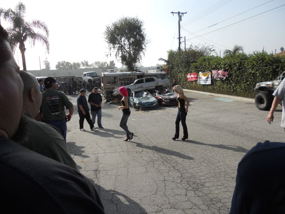 Scene with wrecked cars, two women, and onlookers