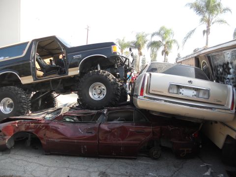 1986 Ford Bronco - A heavily modified 1986 Ford Bronco is perched atop a pile of wrecked vehicles.