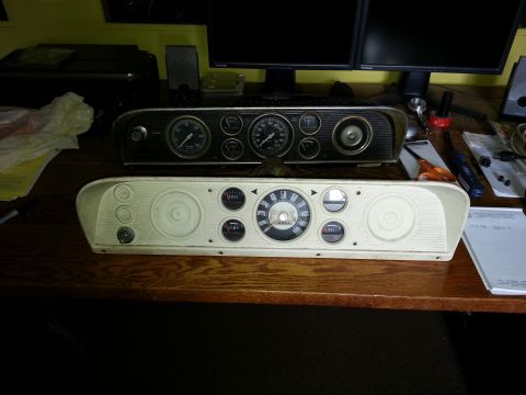 1967 Ford F-100 - Two vehicle instrument clusters are displayed on a desk, likely for restoration or comparison.