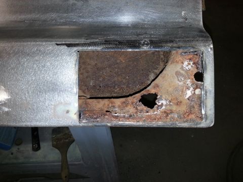 1967 Ford F-100 - Detail of corroded metal, likely a vehicle part undergoing repair or assessment.