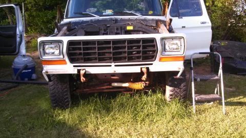 1979 Ford Bronco - A white 1978 Ford Bronco is parked outdoors with its hood up, next to a step ladder and a shop vac.