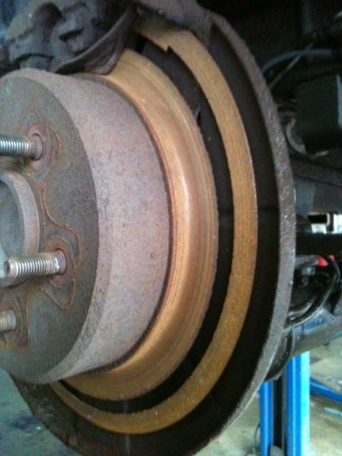 1996 Ford F-150 - Rear brake rotor and caliper assembly, showing rust and wear on the rotor surface.