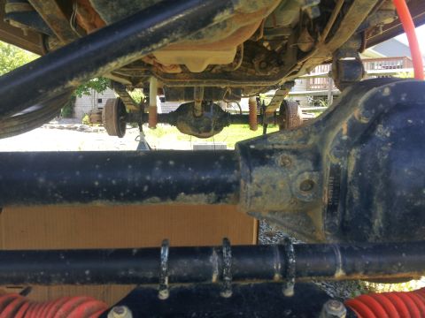 1988 Ford Bronco - Close-up view of the underside of a vehicle, highlighting the rear axle and suspension system.