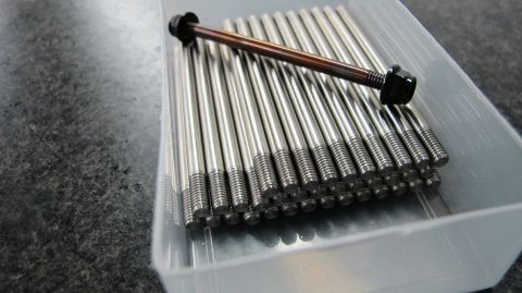 1996 Ford Bronco - A collection of metal bolts are neatly arranged in a clear plastic container.