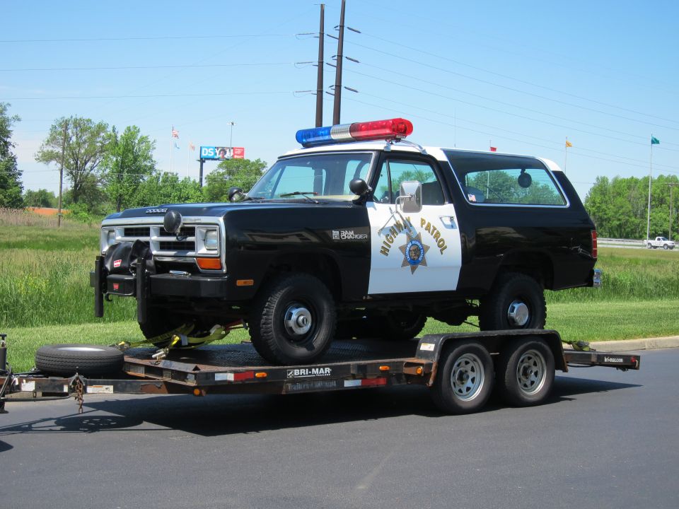 Black-and-white Dodge Ramcharger Highway Patrol SUV on a flatbed trailer