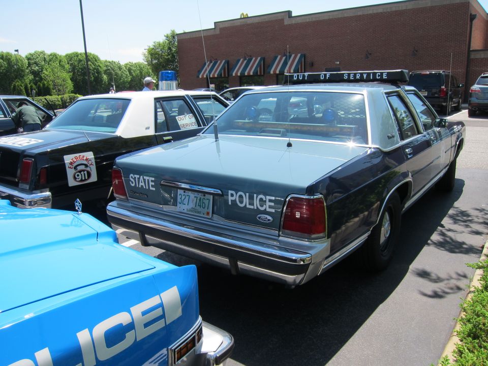 Rear view of a blue State Police Ford sedan with Out of Service light bar
