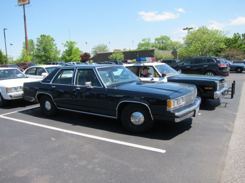 1991 Ford LTD Crown Victoria - dark blue Ford LTD Crown Victoria sedan with chrome trim parked among police cruisers on a sunny day.