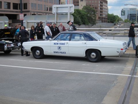 1991 Ford LTD Crown Victoria - white 'New York State Police' Ford sedan parked on a street as a group of people in uniform gather behind it.