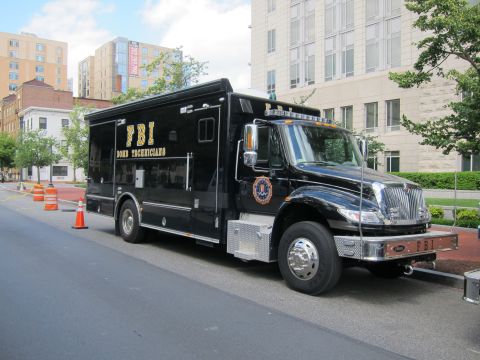 1991 Ford LTD Crown Victoria - black FBI Bomb Technicians box truck with gold lettering and a seal decal parked along a downtown street.