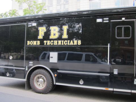 1991 Ford LTD Crown Victoria - Close view of a black truck's side panel reading FBI Bomb Technicians in gold lettering above large wheels.