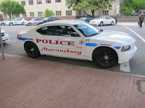 1991 Ford LTD Crown Victoria - white City of Martinsburg police sedan with red and blue markings parked along a brick-paved curb.