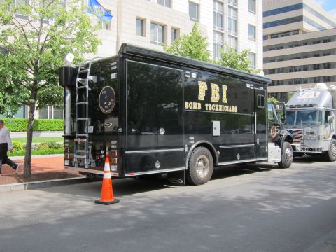1991 Ford LTD Crown Victoria - black FBI Bomb Technicians truck parked beside an orange traffic cone, with another emergency truck behind it.
