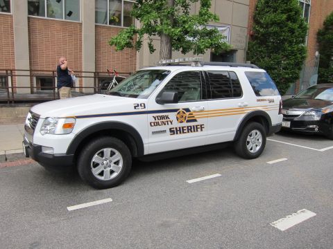 1991 Ford LTD Crown Victoria - Side view of a white York County Sheriff Ford Explorer marked 29 parked in a marked street space.
