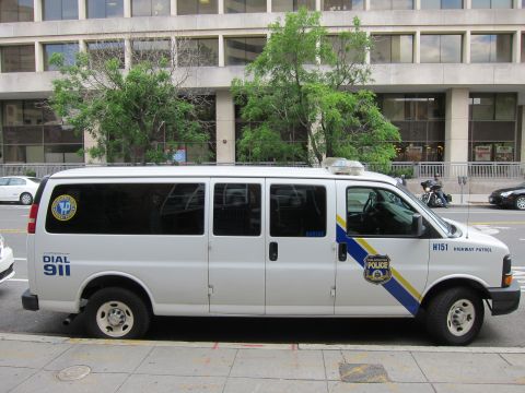 1991 Ford LTD Crown Victoria - Side profile of a white police Chevrolet passenger van marked Highway Patrol H151 and Dial 911.