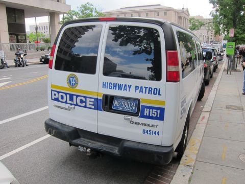 1991 Ford LTD Crown Victoria - Rear view of a white Chevrolet police van marked Highway Patrol with a Pennsylvania plate MG-5803A at a curb.