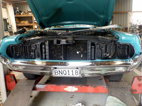 1964 Mercury Monterey - Front view of a teal 1964 Mercury Monterey with its hood open, undergoing service on a lift.