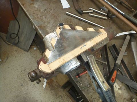 1964 Mercury Monterey - A custom metal part is being shaped and fitted using a vise and template on a workbench.