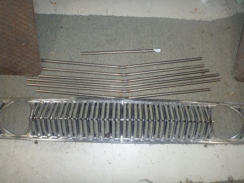 1964 Mercury Monterey - Grille and trim pieces from a 1964 Mercury Monterey are laid out on the floor.