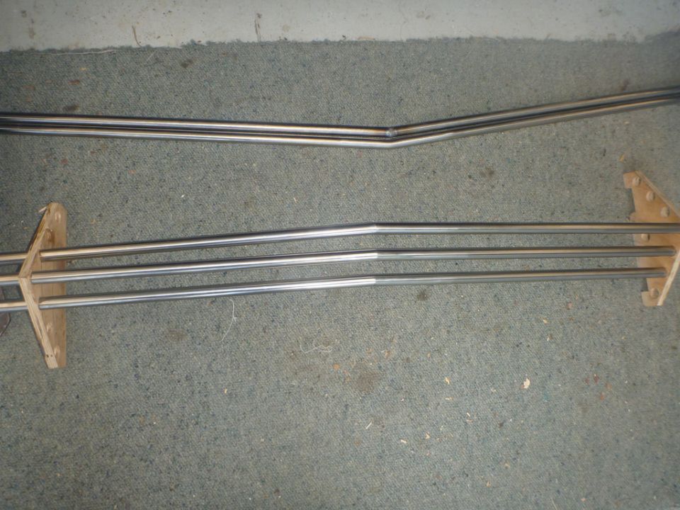 Two sets of chrome trim pieces, one bent, resting on carpet