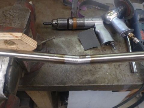 1964 Mercury Monterey - A metal pipe is being worked on with various tools, including a vise and air-powered sander.